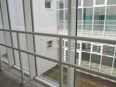 Yeni beyaz çerçeveler ve pencereler. Okul çocuklarının güvenliği için metal çitler. Yeni modern okul. Pencereden karşı duvara ve pencerelere bak. Güvenlik sistemleri. İçişleri Bakanlığı.