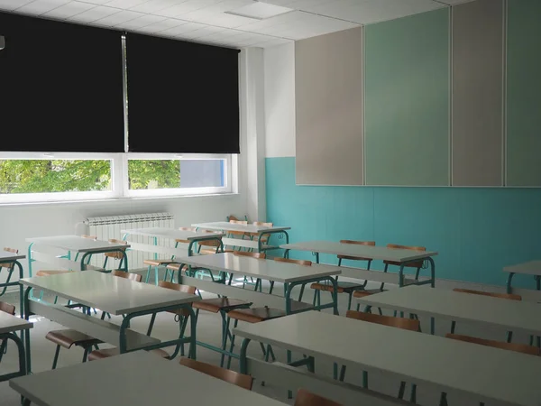 Lecture room with empty seats. Business seminar education. Modern new school. White furniture. Large windows with blackout curtains or blinds. Empty school classroom. Furniture and school equipment.
