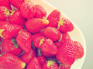 Tabakta çilek, beyaz arka plan. Beyaz tabaklar ve lezzetli kırmızı büyük bahçe çilekleri. Sağlıklı yiyecekler, vitaminler ve vejetaryen diyeti. Yiyeceklerle yaşam. Uzayı kopyala Düz yatıyordu.