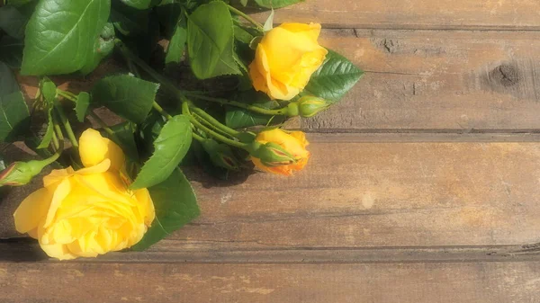 木制背景上的黄色玫瑰 美丽的一束3朵玫瑰在黑暗的木制桌子上 3月8日母亲节或情人节贺卡 — 图库照片
