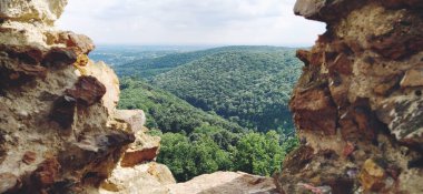 Ruins of an old fortress in Vrdnik, Sremska Mitrovica, Vojvodina, Serbia. Ancient stone walls with mountain ranges in the background. Tourist sights. Embrasure or window for observation and defense.