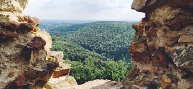 Ruins of an old fortress in Vrdnik, Sremska Mitrovica, Vojvodina, Serbia. Ancient stone walls with mountain ranges in the background. Tourist sights. Embrasure or window for observation and defense.