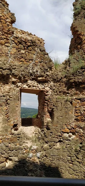 Ruins of an old fortress in Vrdnik, Sremska Mitrovica, Vojvodina, Serbia. Ancient stone walls with mountain ranges in the background. Tourist sights. Embrasure or window for observation and defense.
