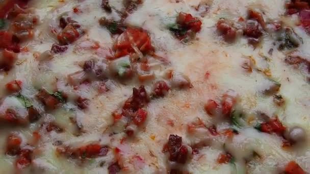 Pizza entière à proximité. Délicieuse pizza ronde juteuse aux tomates, salami. Le fromage fondu se déverse sur la surface du gâteau cuit au four. Vue supérieure et latérale de la pizza. — Video