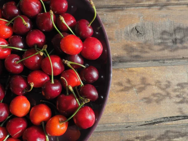 樱桃背景 多汁成熟美味的樱桃或甜樱桃特写从上方在黑暗的盘子和木制背景 夏天的水果和浆果 维生素饮食 — 图库照片