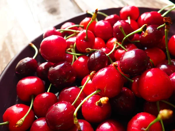 樱桃背景 多汁成熟美味的樱桃或甜樱桃特写侧视图在黑暗的盘子和木制背景 夏天的水果和浆果 维生素饮食 — 图库照片