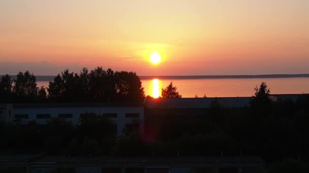 Sarı-turuncu şafak ve yazın Onega Gölü 'nde güneşin yükselişi. Güneş doğuyor ve bulutlardan güneş diskini kaldırıyor. Güneşin sudaki yansıması. Suyun yüzeyindeki güneş izi. — Stok video