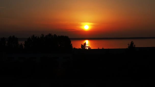 Sarı-turuncu şafak ve yazın Onega Gölü 'nde güneşin yükselişi. Güneş doğuyor ve bulutlardan güneş diskini kaldırıyor. Güneşin sudaki yansıması. Suyun yüzeyindeki güneş izi. — Stok video