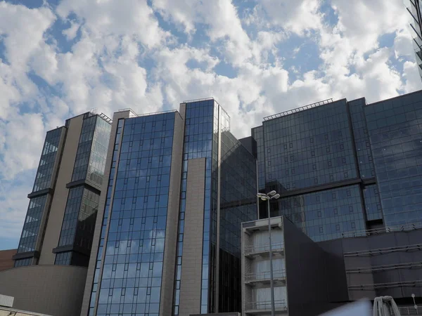 The sky and glass facade of the building. Reflection of the blue sky and white clouds on the glass wall. City skyscrapers. Modern glass buildings and architecture. The concept of ecology