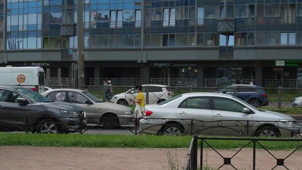 Sint-Petersburg, Rusland, 23 juni 2021. Mensen lopen op de stoep. Het leven van een grote stad. Verkeer van auto 's, bussen, vrachtwagens. Een menigte mensen beweegt zich langs de weg. Zomer, dag, zonnig weer. — Stockvideo