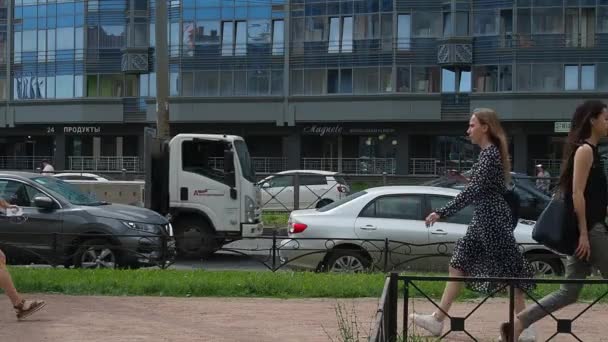 Sint-Petersburg, Rusland, 23 juni 2021. Mensen lopen op de stoep. Het leven van een grote stad. Verkeer van auto 's, bussen, vrachtwagens. Een menigte mensen beweegt zich langs de weg. Zomer, dag, zonnig weer. — Stockvideo