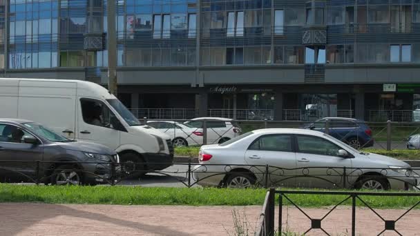 Sankt Petersburg, Ryssland, 23 juni 2021. Folk går på trottoaren. En storstads liv. Trafik med bilar, bussar, lastbilar. En folkmassa rör sig längs vägen. Sommar, dag, soligt väder. — Stockvideo