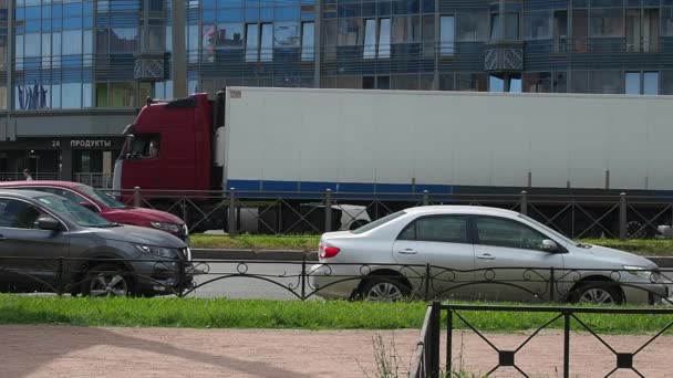 São Petersburgo, Rússia, 23 de junho de 2021. As pessoas andam no passeio. A vida de uma cidade grande. Tráfego de carros, autocarros, camiões. Uma multidão de pessoas se move ao longo da estrada. Verão, dia, tempo ensolarado. — Vídeo de Stock