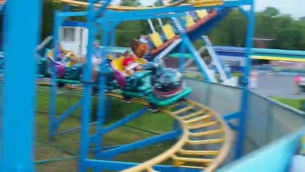 Petrozavodsk, Rusland. 26 juni 2021. Kinderen en volwassenen rijden een achtbaan in het pretpark en recreatie. Trein met. — Stockvideo