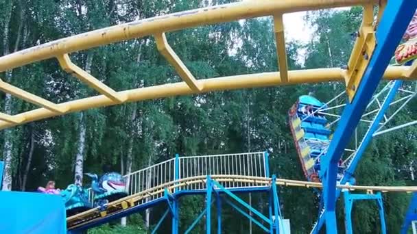 Petrozavodsk, Rusia. 26 de junio de 2021. Niños y adultos montan en una montaña rusa en el parque de atracciones y recreación. Ingenio del tren. — Vídeos de Stock