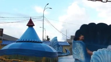 Petrozavodsk, Rusya, 26 Haziran 2021. İnsanlarla dolu bir atlıkarınca. Platform, tırmanışlar ve inişlerle dairesel bir hareket yapıyor. Kabukların kabinleri özgürce dönüyor. Çocuklar ve yetişkinler için mutluluk ve neşe