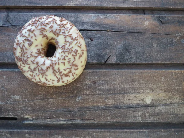 Donut Großaufnahme Auf Holzgrund Köstlicher Kuchen Mit Vanillezucker Und Schokoladenstreusel — Stockfoto