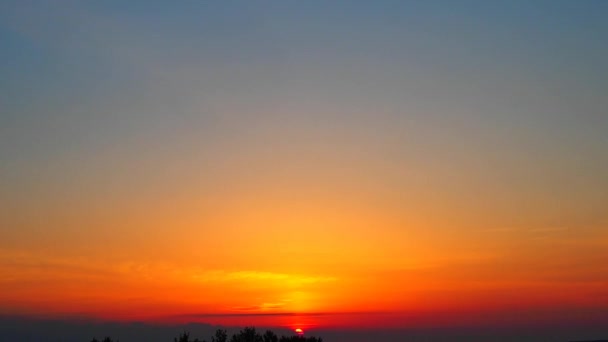На світанку пташина чайка пролітає над небом. Жовто-оранжевий світанок і сходження сонця над озером Онега влітку. Сонячний диск піднімається і піднімається з хмар. — стокове відео