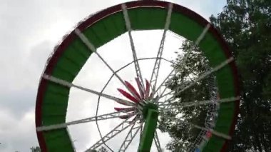 Eğlence ve eğlence parkında eğlence eğlencesi sürprizi. Çocuklar ve yetişkinler atlıkarıncaya biniyor. Açılı bir platform. İnsanlar duygulardan, dönüşlerden ve tekerleğin hareketlerinden hoşlanır.