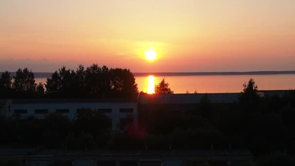 Жовто-оранжевий світанок і сходження сонця над озером Онега влітку. Сонячний диск піднімається і піднімається з хмар. Відбиття сонця у воді. Сонячний трек на поверхні води. — стокове відео