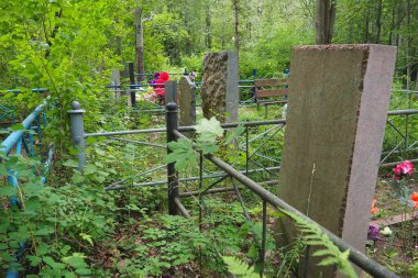 Taş anıtlı bir mezarlık. Yazın öğleden sonra terk edilmiş eski bir mezarlık. Çimen çalıları. Mezarlardaki eski granit anıtlar. İnsan mezarları. Unutulma, sakinlik, ölüm ve Cadılar Bayramı teması.