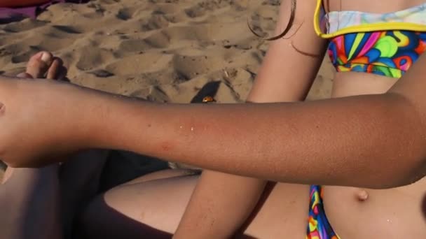 Petrozavodsk, Rusia, 10 de julio de 2021. Una chica en una playa de arena. Un escarabajo mariquita se arrastra en la mano de los niños. La chica protege al escarabajo. Insectos en la playa. Ayuda para los animales. Verano playa diversión — Vídeos de Stock