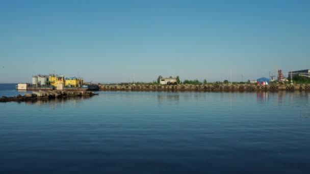 Petrozavodsk, Rusya, 10 Temmuz 2021 Nehir İstasyonu veya limanı. Depolar ve üretim tesisleri. Onega Gölü 'ndeki iskele, Karelia. Araba lastikleri rıhtımın kenarlarına yerleştirilir. Su, gökyüzü ve ufuk. — Stok video