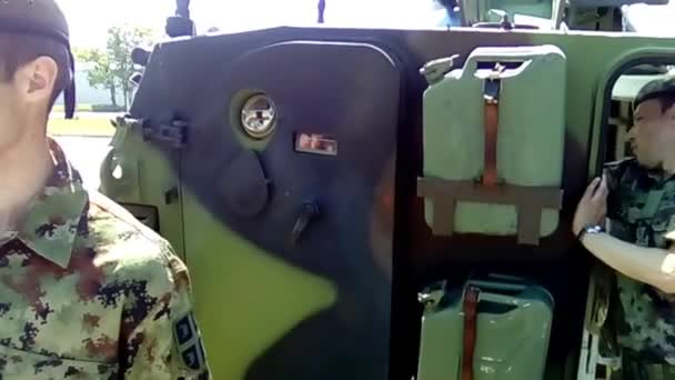 スレムスカ・ミトロヴィツァセルビア2019年5月18日戦車部隊のデモンストレーション。兵士は装甲兵員輸送車のドアを開ける。子供たちが飛び出す。兵士は少年からタンクヘルメットを削除します。. — ストック動画