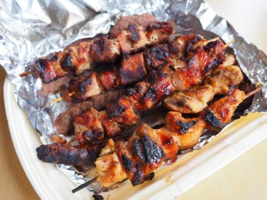 Tek kullanımlık paketlerde ızgara et ve alüminyum folyo, bir restorandan geliyor. Restoran ve kafelerden eve yemek teslimatı. Şiş kebap ve topak topak tavuk, domuz ve kuzu eti.