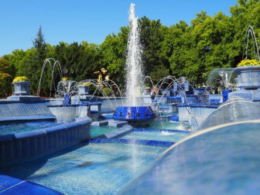 Subotica, Sırbistan 12 Eylül 2021. Belediye binasının yanındaki meydanda mavi bir çeşme var. Monogramlı mavi seramik parçalar. Su sıçratan bir çeşme. Mavi suların kenarında güneşli bir yaz günü.