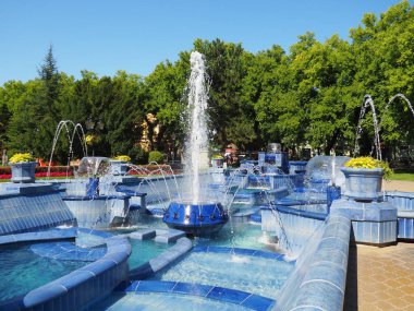 Subotica, Sırbistan 12 Eylül 2021. Belediye binasının yanındaki meydanda mavi bir çeşme var. Monogramlı mavi seramik parçalar. Su sıçratan bir çeşme. Mavi suların kenarında güneşli bir yaz günü.