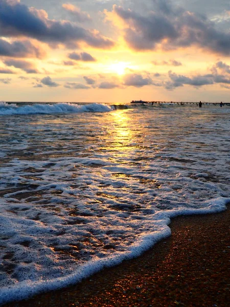 夕阳西下美丽的日落浪花在沙滩上翻滚.Vityazevo，Anapa，黑海。旅游胜地梅卡，健康胜地。夜空中的彩云.光线反射出水面 — 图库照片