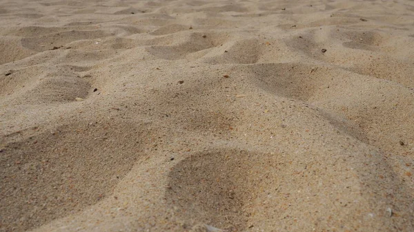 Zand in weinig zonlicht op gouden uur. Leeg strand, voetafdrukken en deuken in het zand. Duinen van de Zwarte Zee. Afzonderlijk sedimentgesteente, bestaande uit korrels van berg- en mineraalkwartssiliciumdioxide — Stockfoto