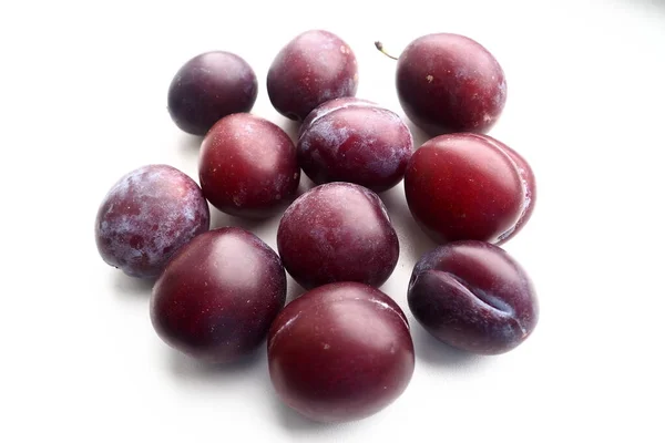 Ciruelas sobre un fondo blanco. Frutas maduras jugosas — Foto de Stock