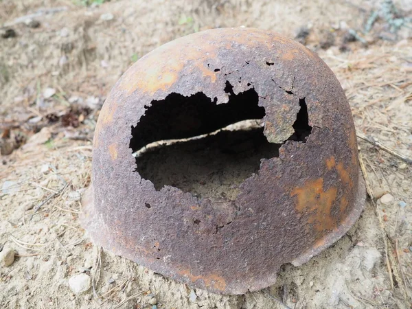 Authentic Second World War helmet with bullet hole. Rusty helmet on the grave - memorial in Orzega, Karelia. Helmet of a soldier who died in 1941