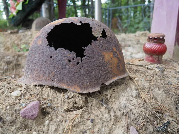 Auténtico casco de la Segunda Guerra Mundial con agujero de bala. Casco oxidado en la tumba - memorial en Orzega, Karelia. Casco de un soldado que murió en 1941 —  Fotos de Stock