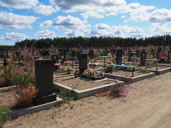 Vilga, Oroszország, 2021. július 21. Városi temető friss sírokkal, fából és kőből készült sírkövekkel, fém keresztekkel. Nyáron süt a nap. Homokos talaj beton műemlékek és kerítések alatt. — Stock Fotó