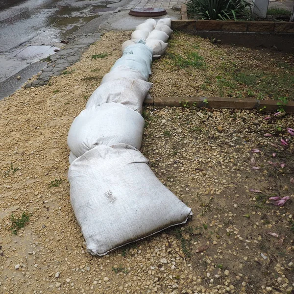 Des sacs de sable sont placés sur le sol à côté de la route pour éviter les inondations et les débordements. Protection contre les intempéries, les cyclones et les ouragans. Une affaire d'assurance. Anapa, Krasnodar, Russie, août 2021 — Photo