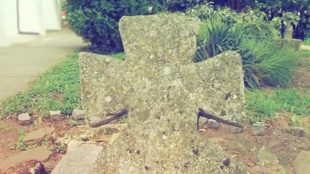 여름에 묘지에 오래 된 석조 십자가가 있었어요. 안개가 배경을 흐릿하게 했습니다. 할로윈 테마. 십자가의 오래 된 이끼 묘비. 신비 한 곳이죠. 버드나무의 장막. 고전주의와 빈티지 스타일 — 비디오