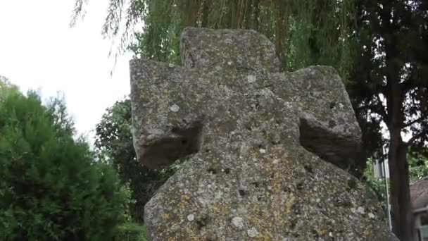 Vieja cruz de piedra en el cementerio por la tarde en el verano. Tema Halloween. Sremska Mitrovica, Serbia. Antigua lápida de la Cruz musgosa. Un misterioso lugar misterioso. El sauce se balancea — Vídeo de stock