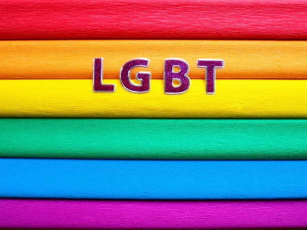 Abreviatura LGBT, texto da carta. Letras LGBT roxas no fundo da bandeira do arco-íris. Uma bandeira do arco-íris, a bandeira do orgulho. Símbolo comunitário LGBTQ. EuroPride 2022 — Fotografia de Stock