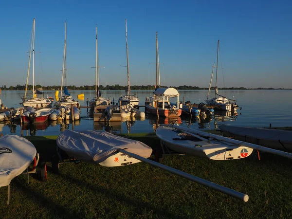 Palic, Serbia, September 11 2021 Boats and yachts on the shores of Lake Palic. Rest on the water. Sports water transport moored off the coast. Tourism and active lifestyle. Horizon line, sky and water