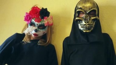 Siyah kostümlü ve korkunç Cadılar Bayramı maskeli çocuklar. Meksikalı Kalaka Calavera maskeli kız. Siyah kapüşonlu korkunç bir kafatası maskesi takan bir çocuk. Cadılar Bayramı Arifesi ya da Azizler Arifesi teması