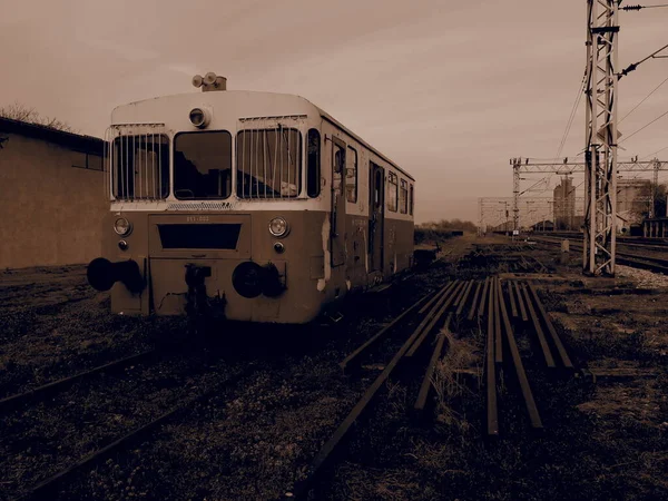 Carro de tren retro. Locomotora vintage fabricada en Yugoslavia. Sremska Mitrovica, Serbia. Sepia. El cuerpo metálico de un vehículo ferroviario. Carriles oxidados. Estación ferroviaria en perspectiva — Foto de Stock