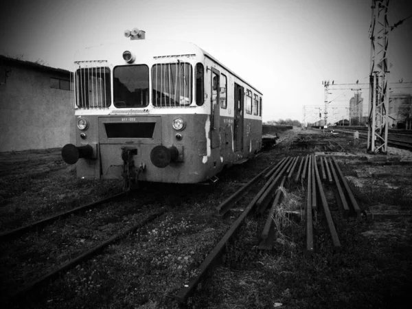 Carro del treno retrò. Locomotiva vintage prodotta in Jugoslavia. Sremska Mitrovica, fotografia in bianco e nero monocromatica. Il corpo metallico di un veicolo ferroviario. Rotaie arrugginite. Stazione ferroviaria. vignettatura scura — Foto Stock