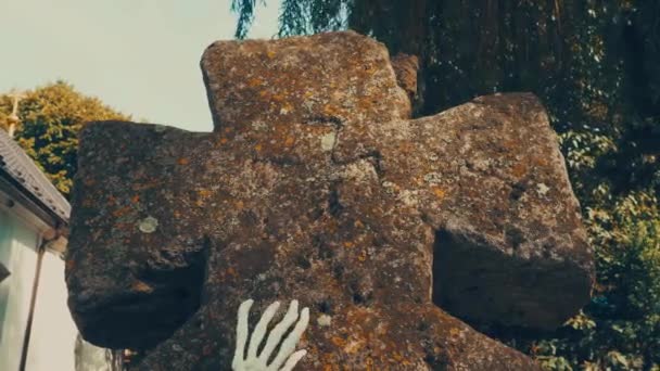 Skeleton zombie ruce zvedající se ze hřbitova, Halloween. Kosti rukou kostlivce na náhrobku. Mrtvý muž, který přišel k životu. Starý křesťanský hřbitov a kamenný mech kříž — Stock video