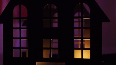 Cadılar Bayramı gecesinin karanlığında, mum ışığı kalenin pencerelerinde parlar, ürkütücü gölgeler bırakır. Atmosfer, ışık altında dans eden siluetler gibi korku ve merakla doluyor..