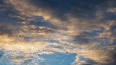 Sarı, turuncu ve pembeye boyanmış hareket eden bulutların büyüleyici güzelliği büyüleyici bir günbatımı mavi gökyüzüne doğru süratle kayıyor. Doğanın renkli başyapıtını hareket halinde tecrübe edin. Hava tahminleri