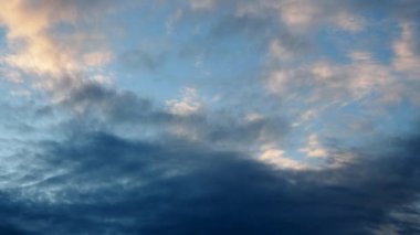 Gün batımında güneş ufukta batarken, bulutların üzerine sıcak renkler dökerek, huzur verici, hayranlık uyandıran bir manzara yaratarak, gökyüzünün hızlı ve nefes kesici dönüşümü. Karanlık yaklaşıyor.