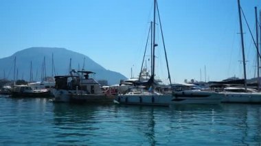 Bar, Montenegro 10 August 2025: Enjoy peaceful view of beautiful harbor. Witness boats gently bobbing in calm waters under clear blue sky, surrounded by majestic mountains. Water tourist excursion.